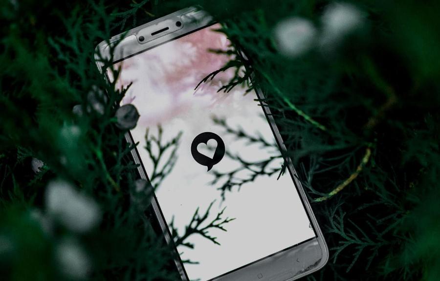 Mobile phone lying in heather, with a heart on the screen