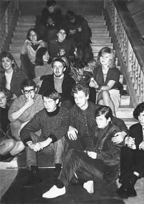 A black and white photo of a group of people sat on a large staircase