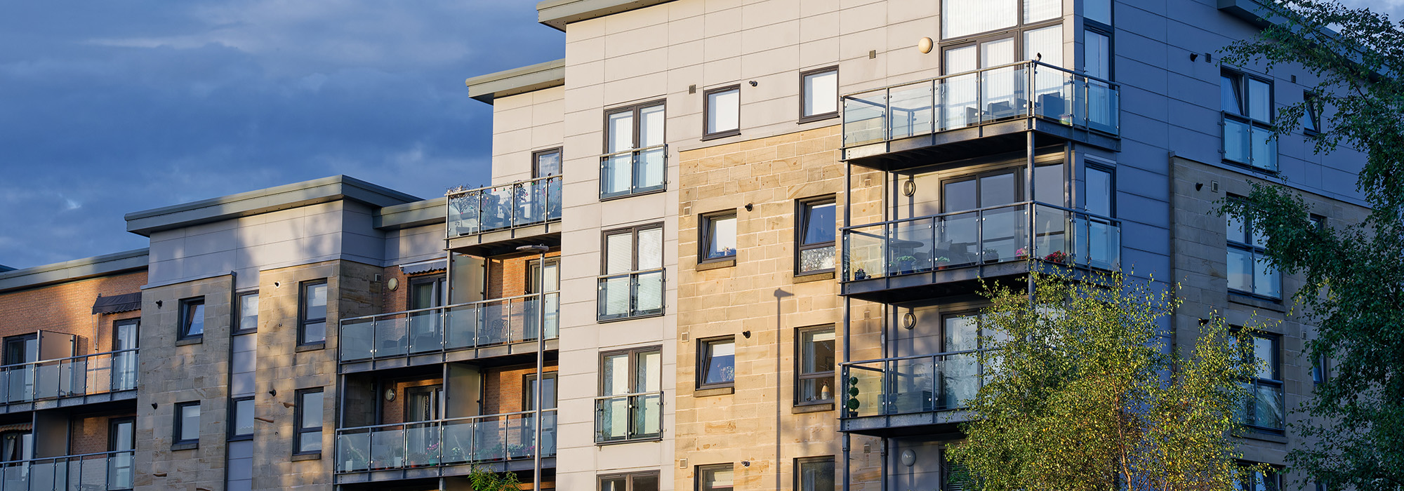 A block of flats against a clear blue sky.