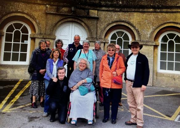 A group of alumni posing for a group photo outside Main House