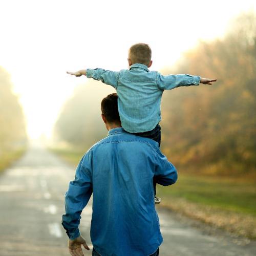 Silhouette of a man with a child on his shoulder