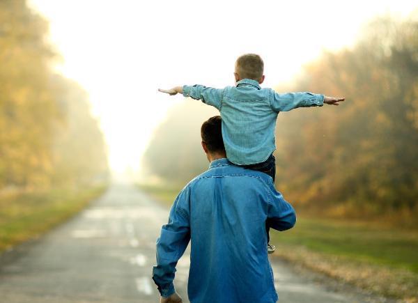Silhouette of a man with a child on his shoulder  
