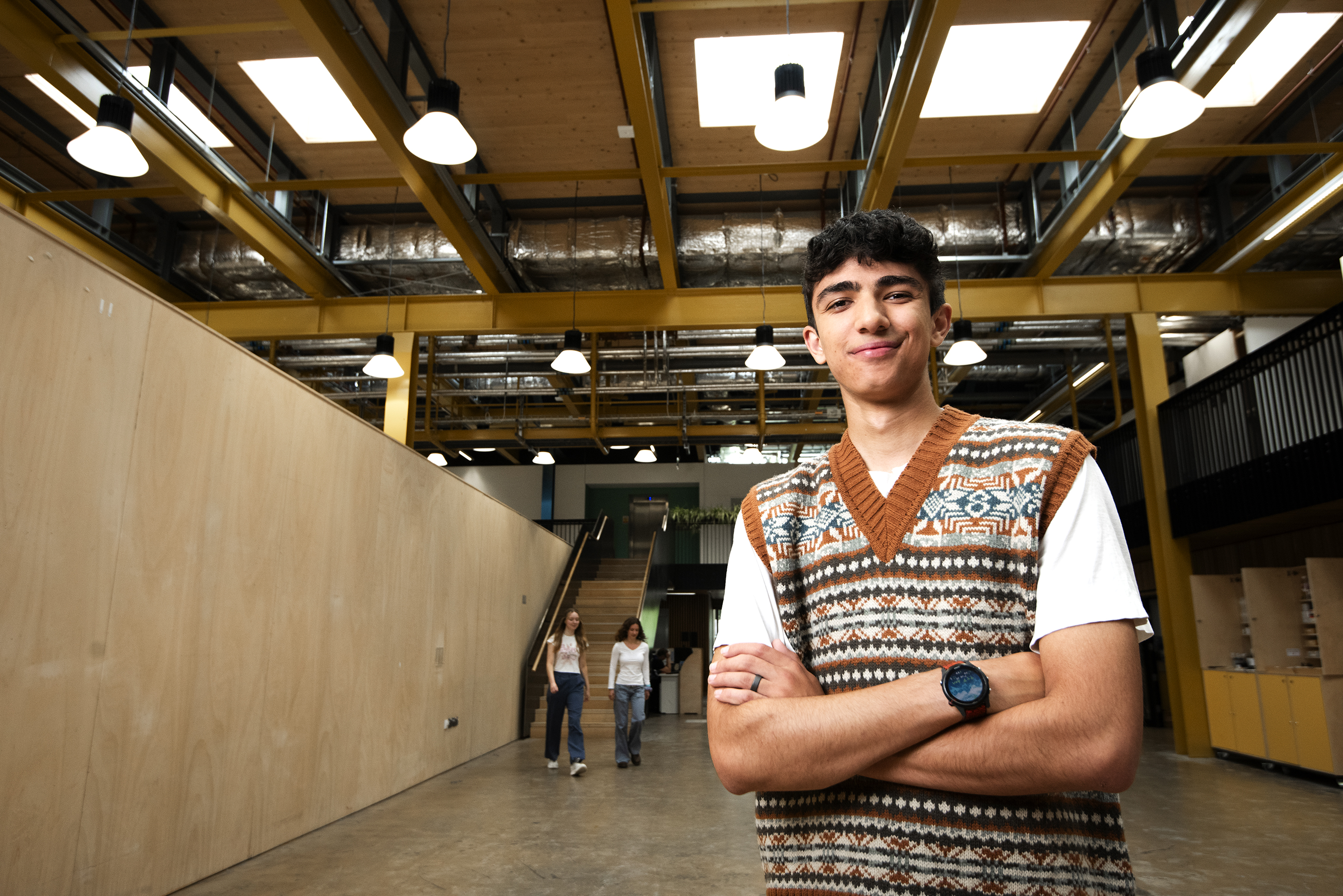 A student stands inside a modern industrial building