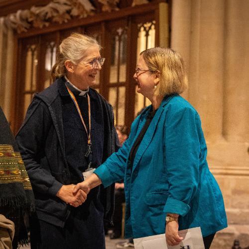 Vice Chancellor shaking hands with lead chaplain in Bath Abbey, smiling