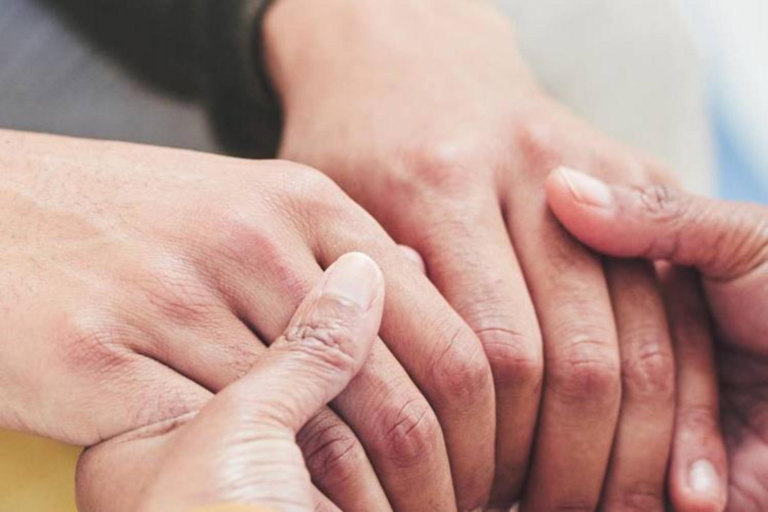 two hands holding in support