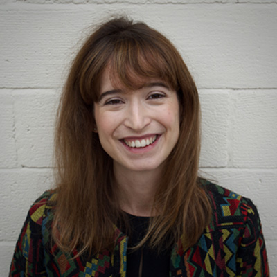 Person with long brown hair smiling