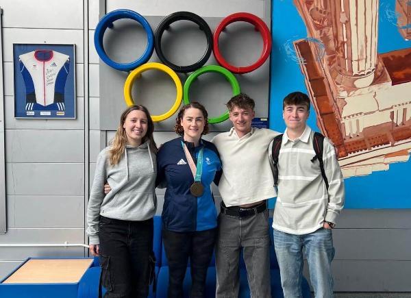 Group of young people stood in line with famous Olympian