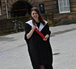 A younger Laura Johnston smiling in her graduation robe