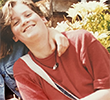A younger Lucy Sweetman smiling outdoors in the sunshine