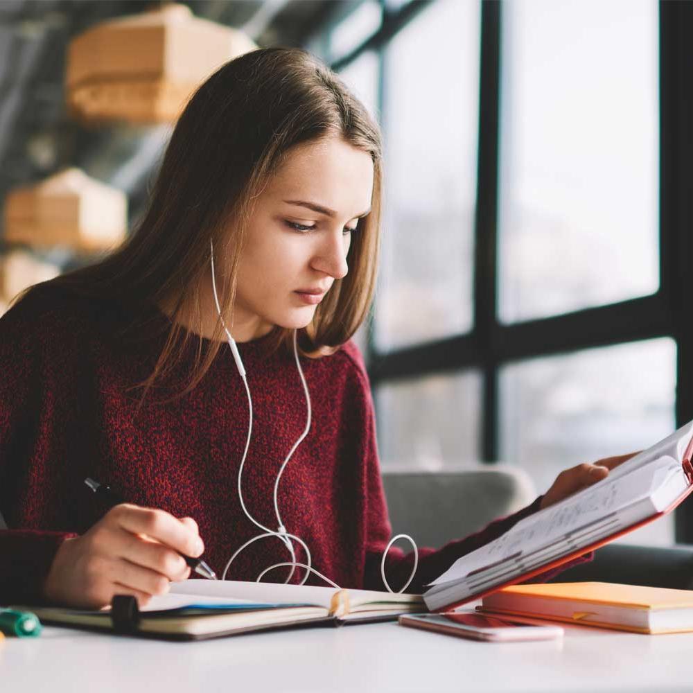 Person with long hair studying in library