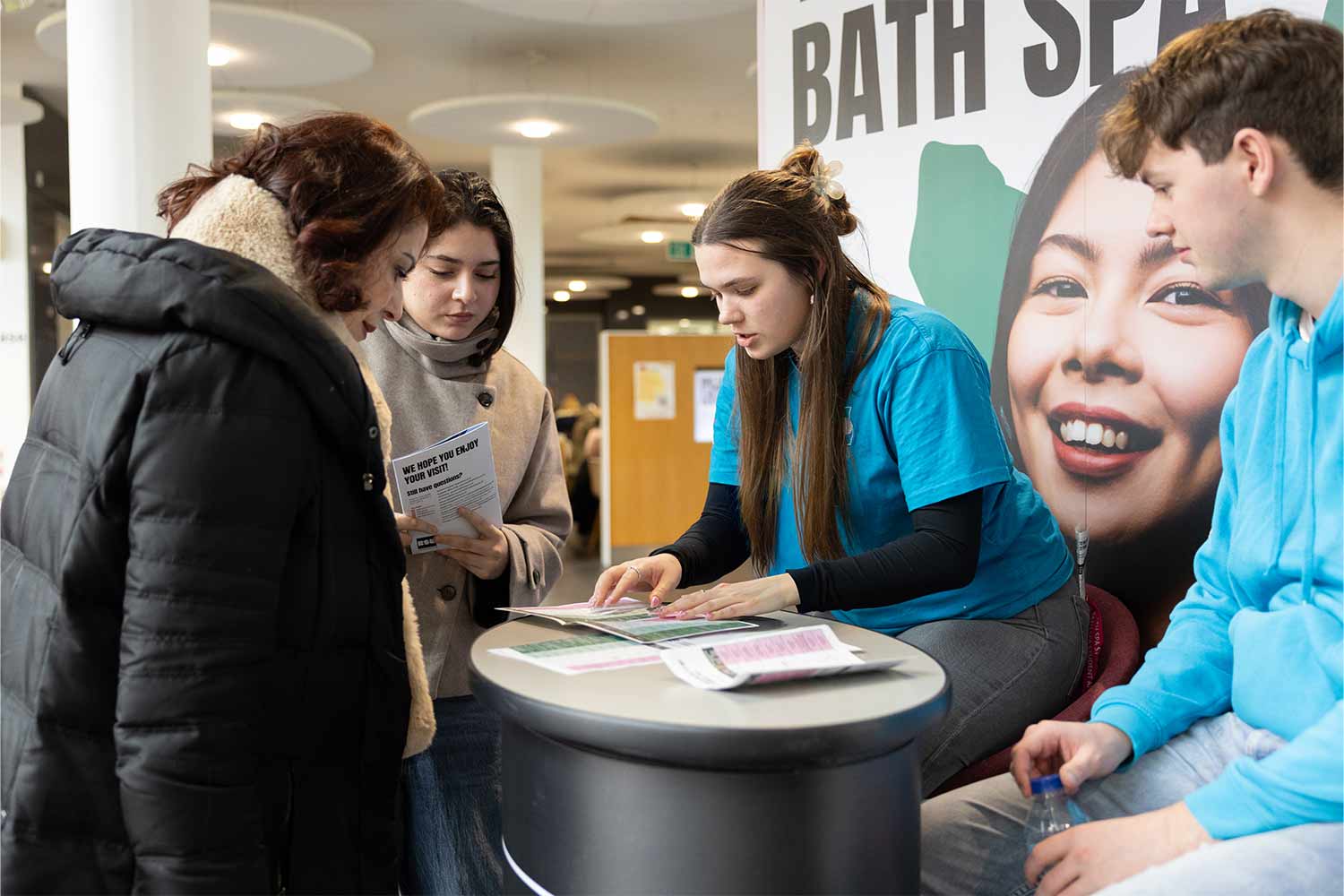 Photograph of Student ambassadors at stall with student and parent