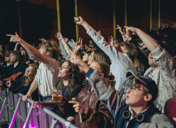 A crowd singing along to a performer