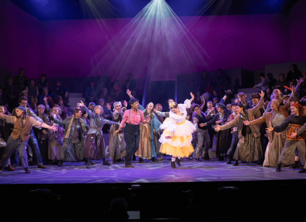 A group of performers dancing and cheering on stage