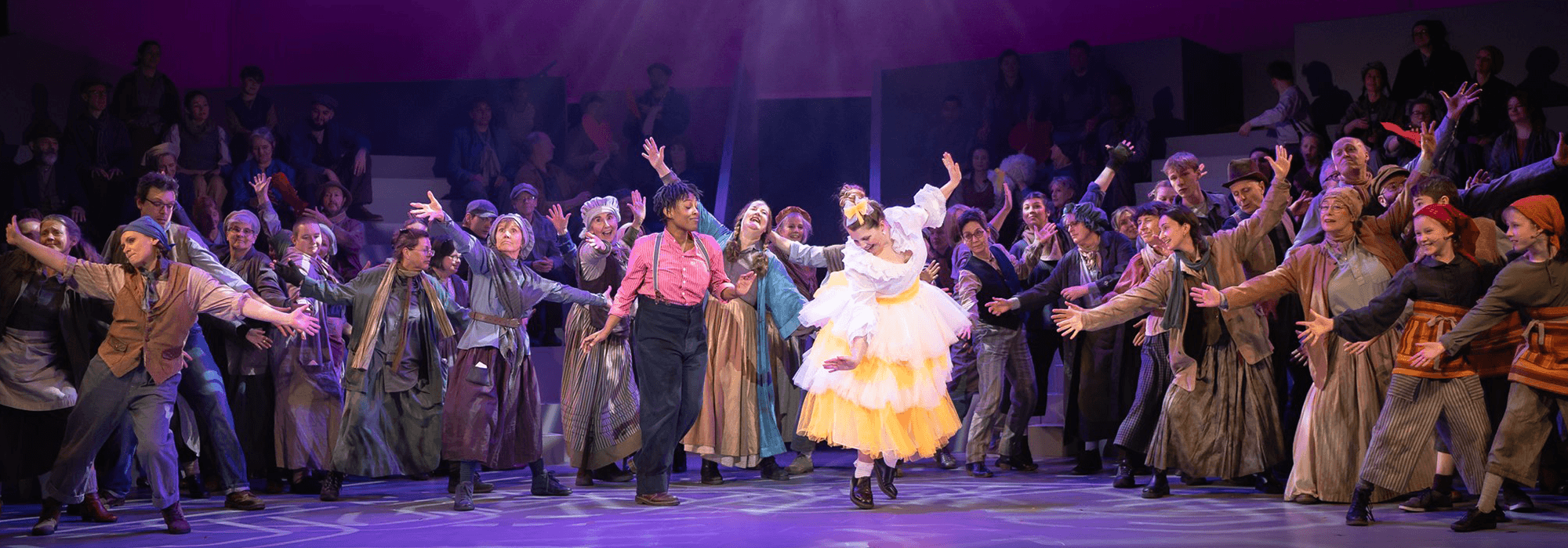 A group of performers dancing and cheering on stage