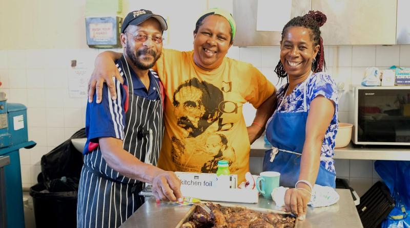 Three smiling people in a kitchen