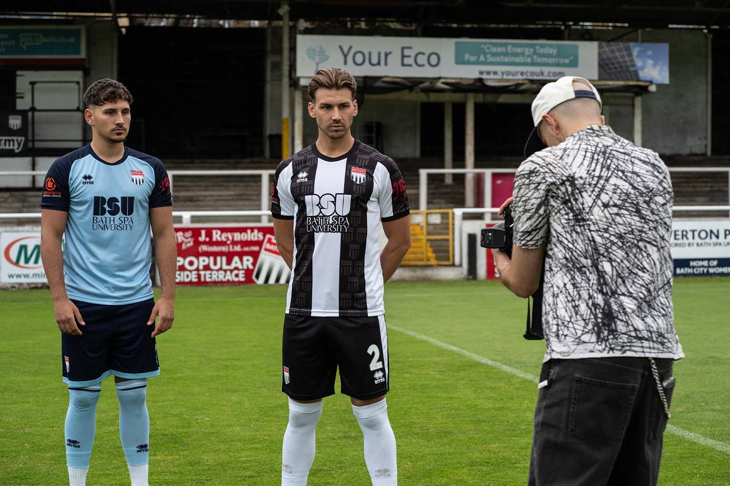 Two Bath City football players wearing new kit on pitch