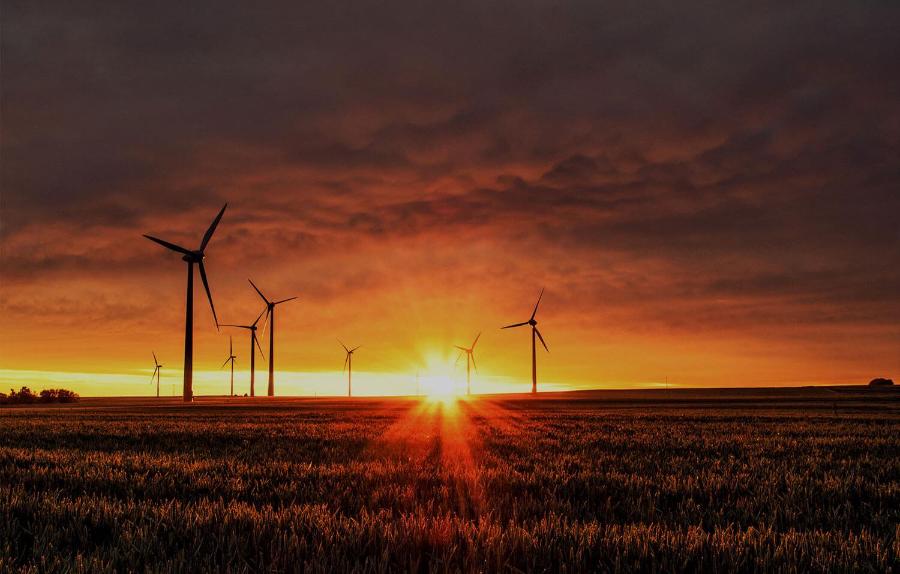 Sunset behind wind turbines on a plain