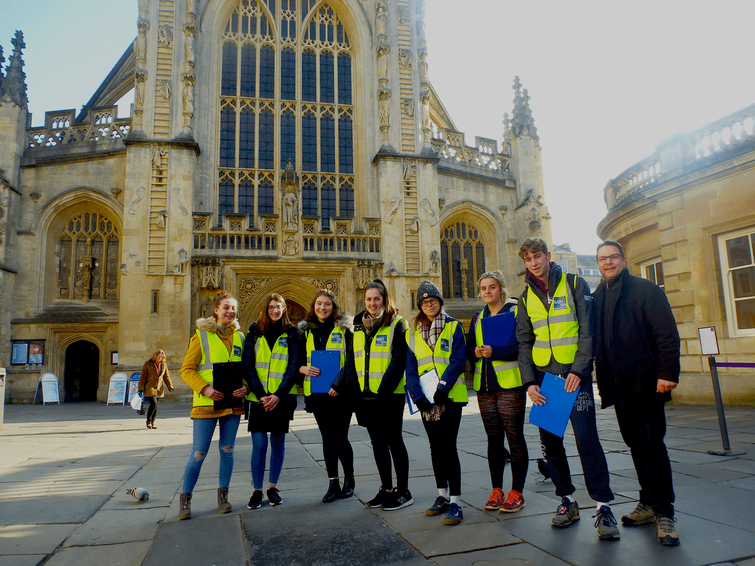 A group of Bath Spa people standing in front of Bath Abbey conducting a survey