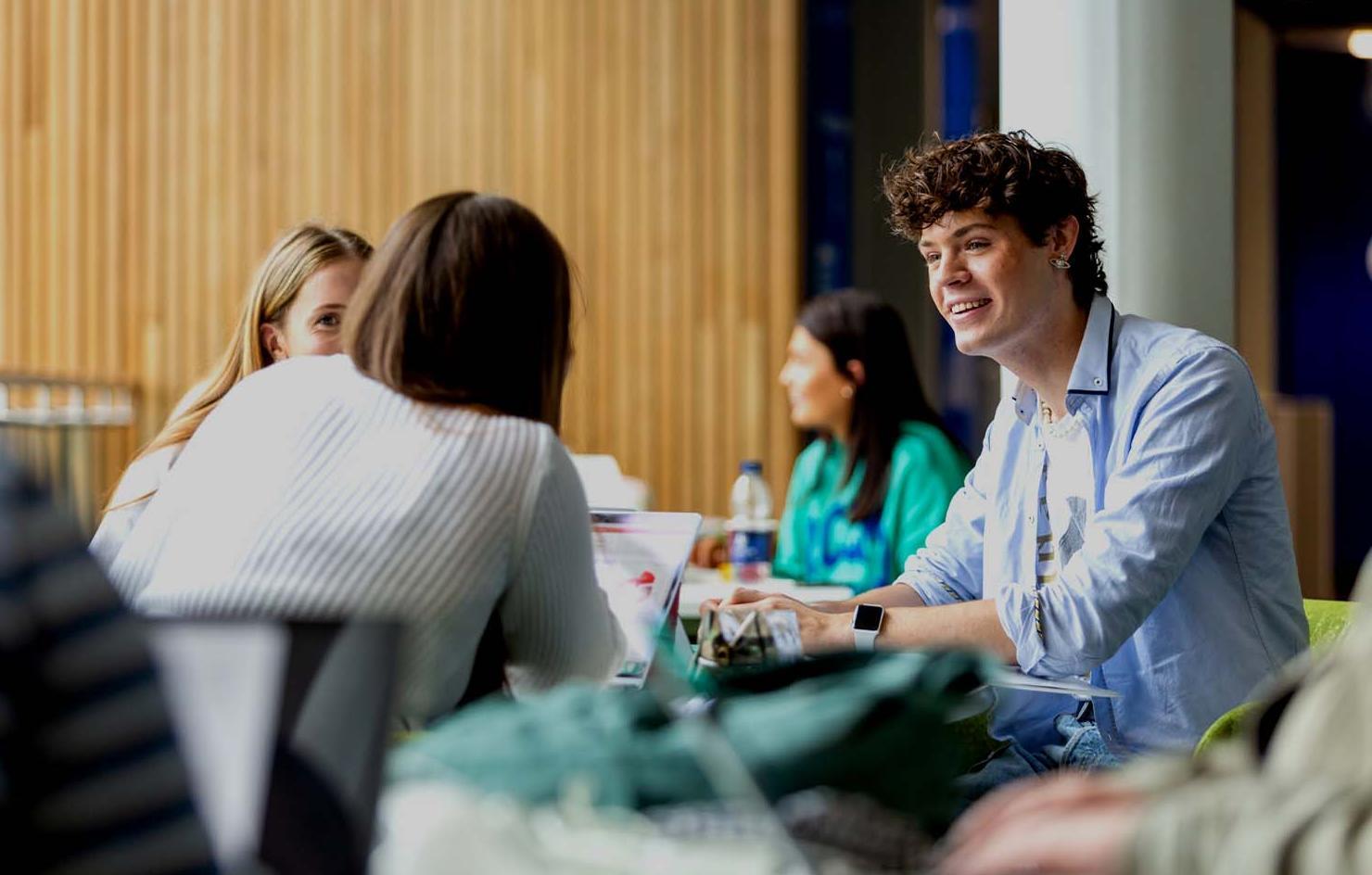 Students chatting around a table in Commons building