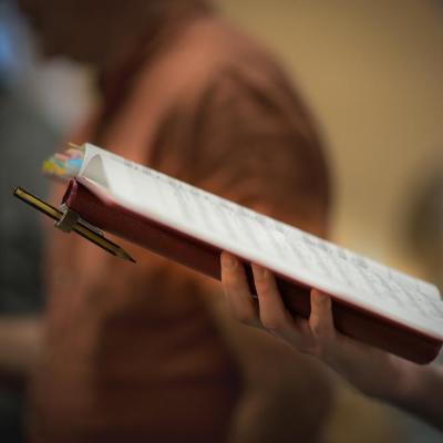 Close-up of a hand holding a music sheet folder