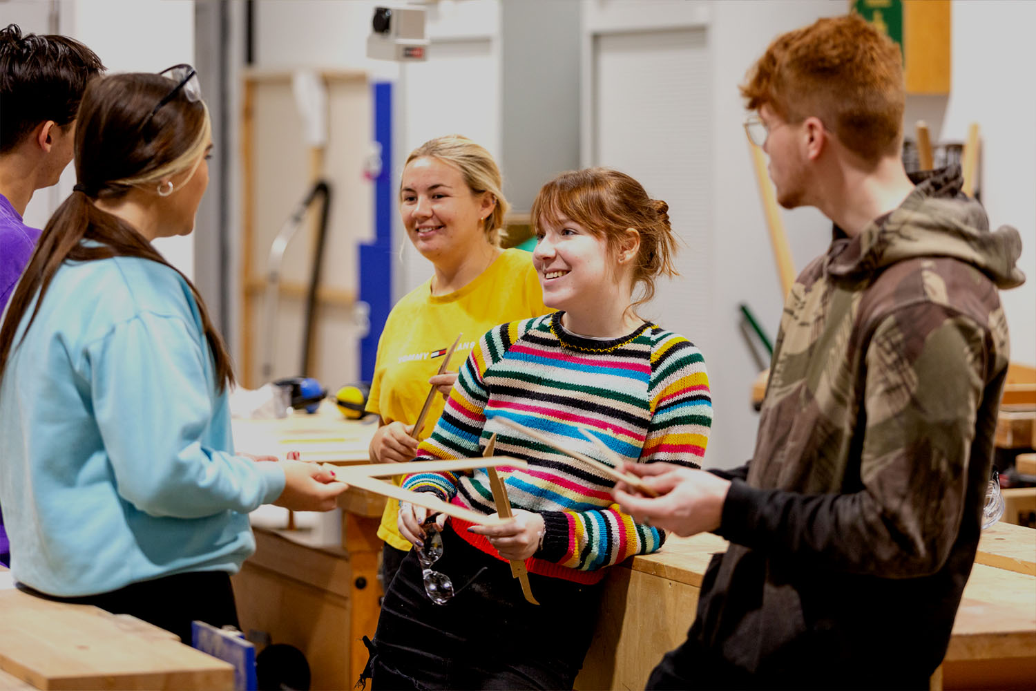 A group of five young students chat together in an art studio at Locksbrook campus