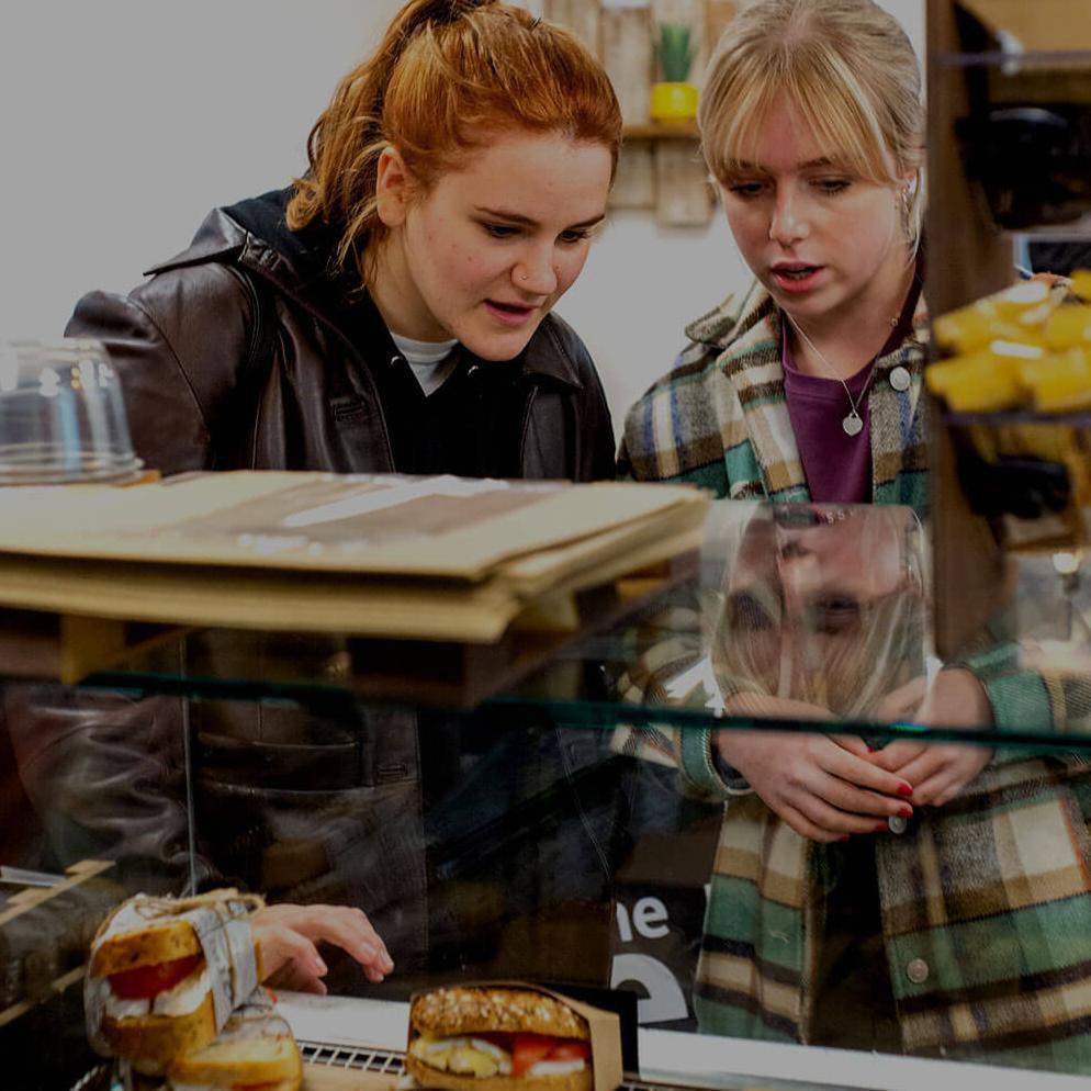 Two students choosing their lunch from a deli counter