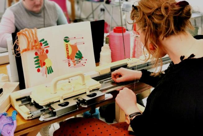 Students working at a knitting machine with a pattern