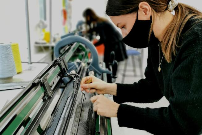 Student using a knitting machine