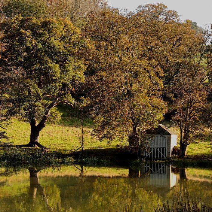 Newton Park lake and boathouse surrounded by autumnal trees