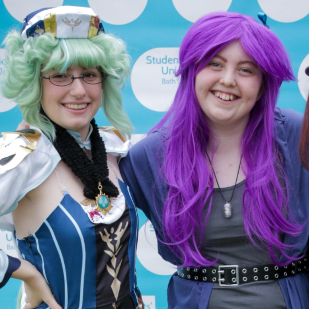 Three students in brightly coloured cosplay outfits