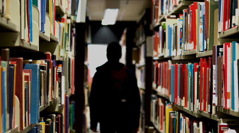 A boy walking through a library
