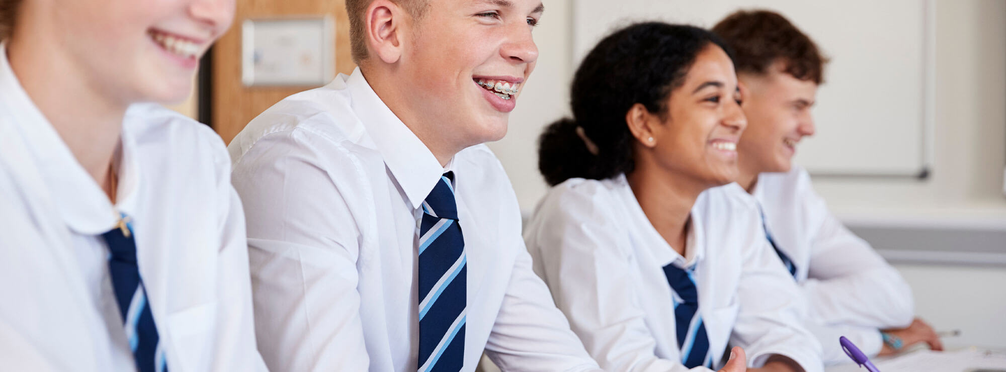 Smiling older school pupils in a classroom