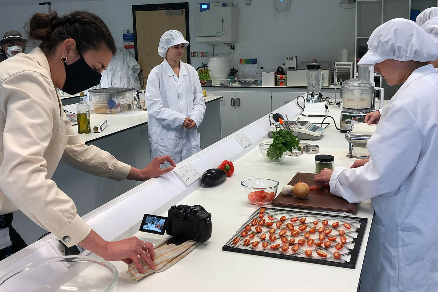 A woman drags a camera on a tea towel along a table in a nutrition laboratory