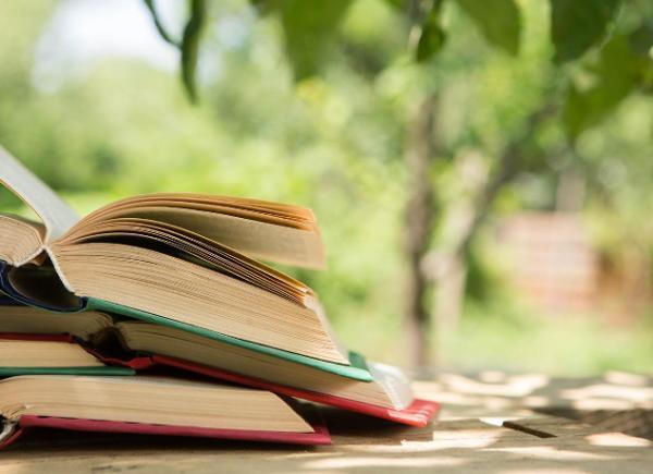 A stack of books in a green summery environment