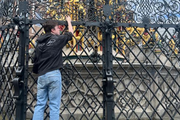 A student looking through a fence in Stuttgart, Germany as part of study abroad.