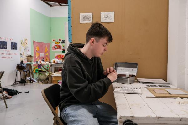 A student working with a sketchbook in a studio at Bath Spa University.