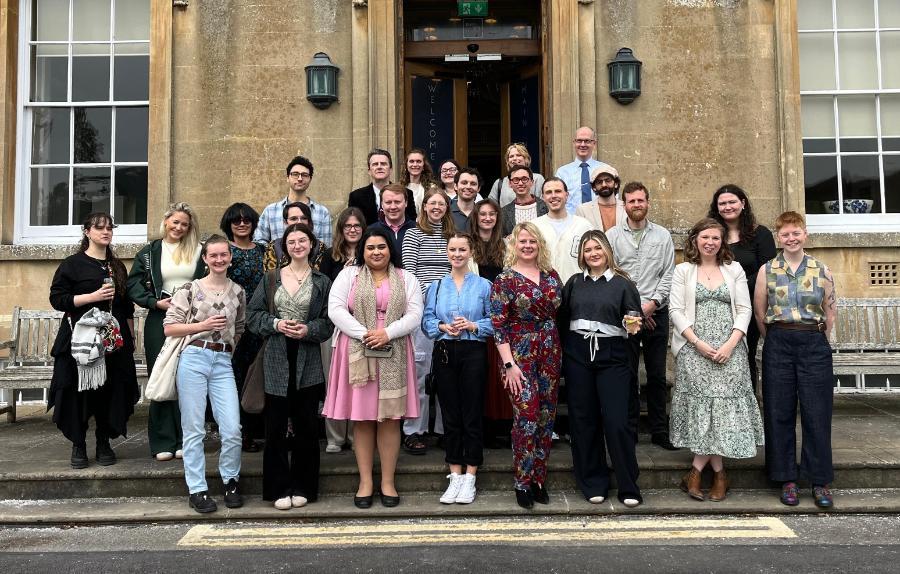 A large group of people standing outside a manor house