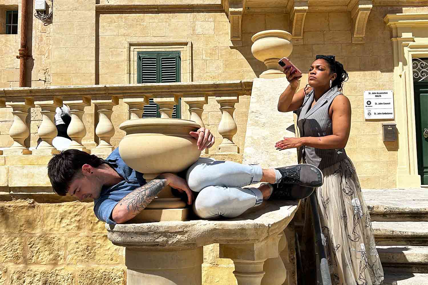 Two people moving around outdoor furniture