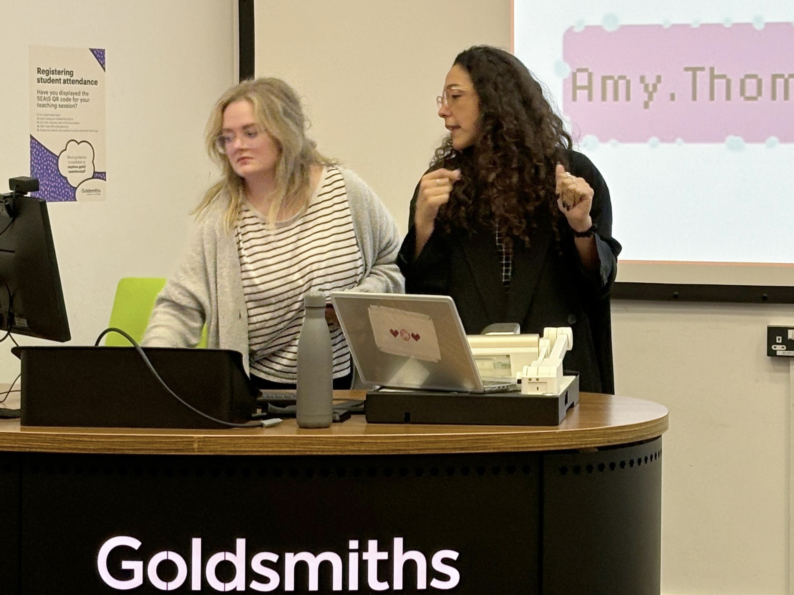 Two presenters stand at a podium