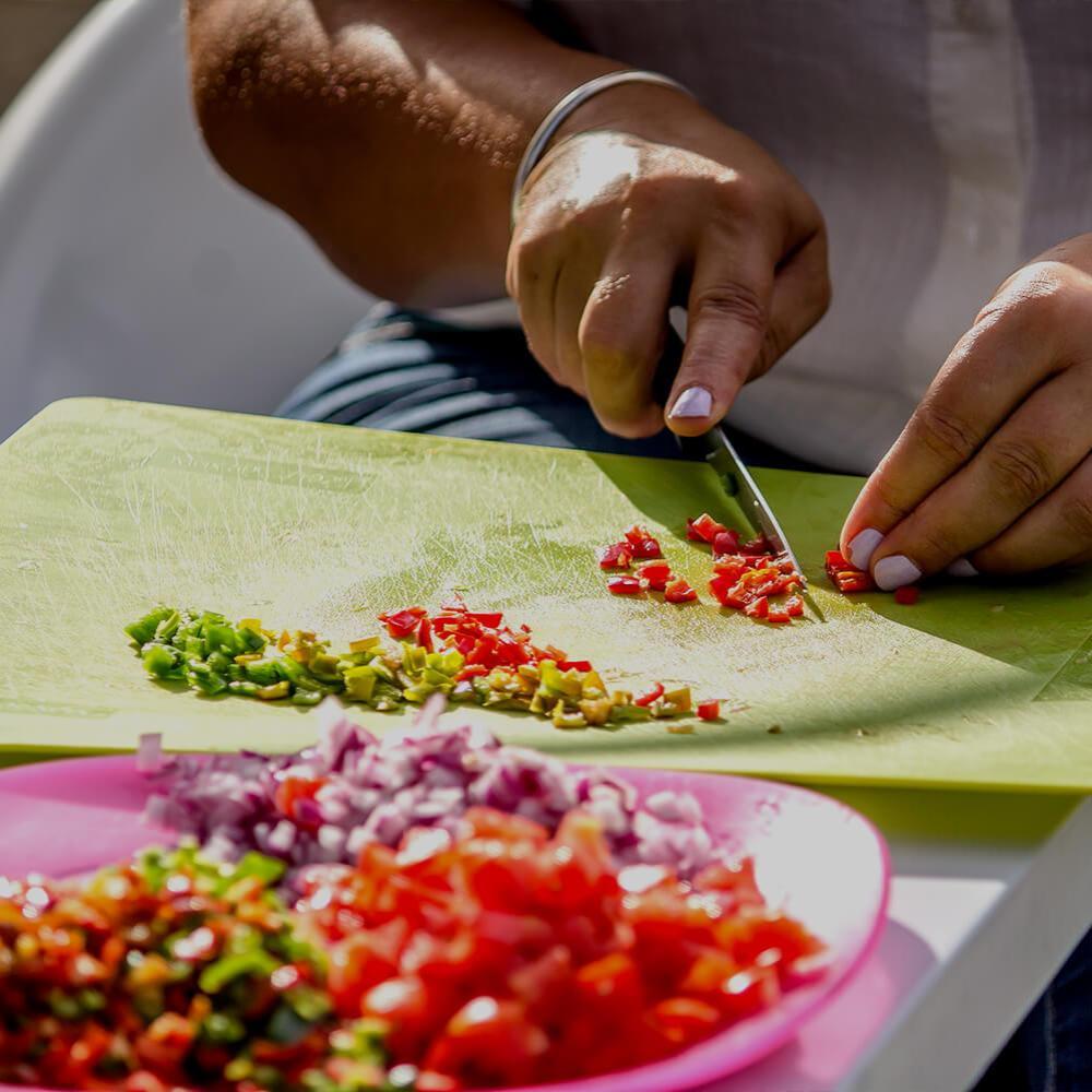 A person chopping salad on a chopping board.