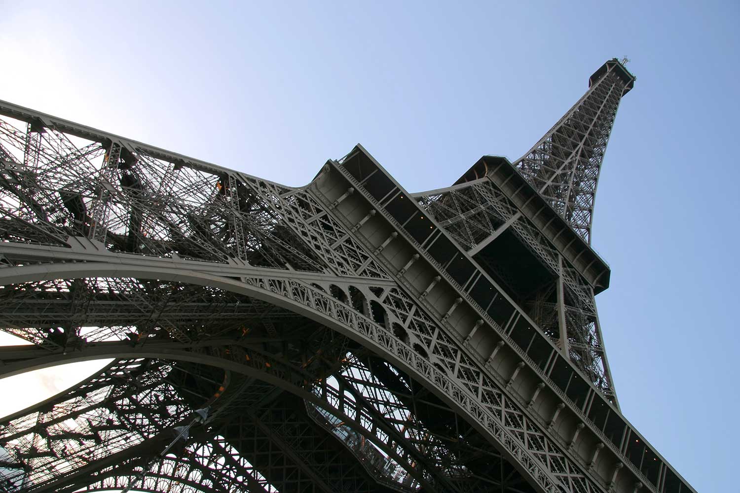 An abstract shot of the Eiffel Tower against a blue sky