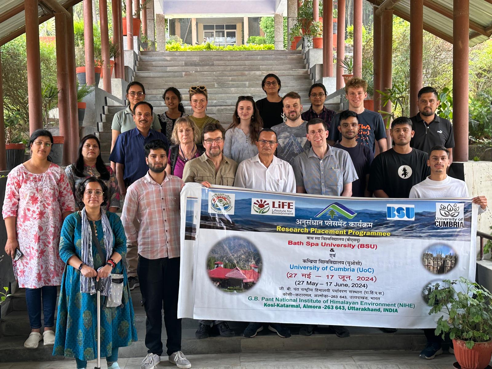 Group of people standing under a covering with a banner