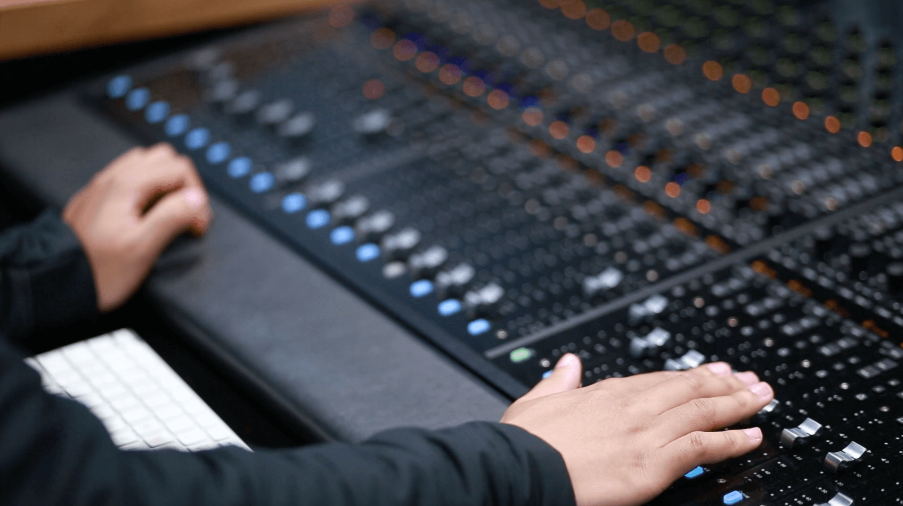 Closeup of a person working at a mixing deck