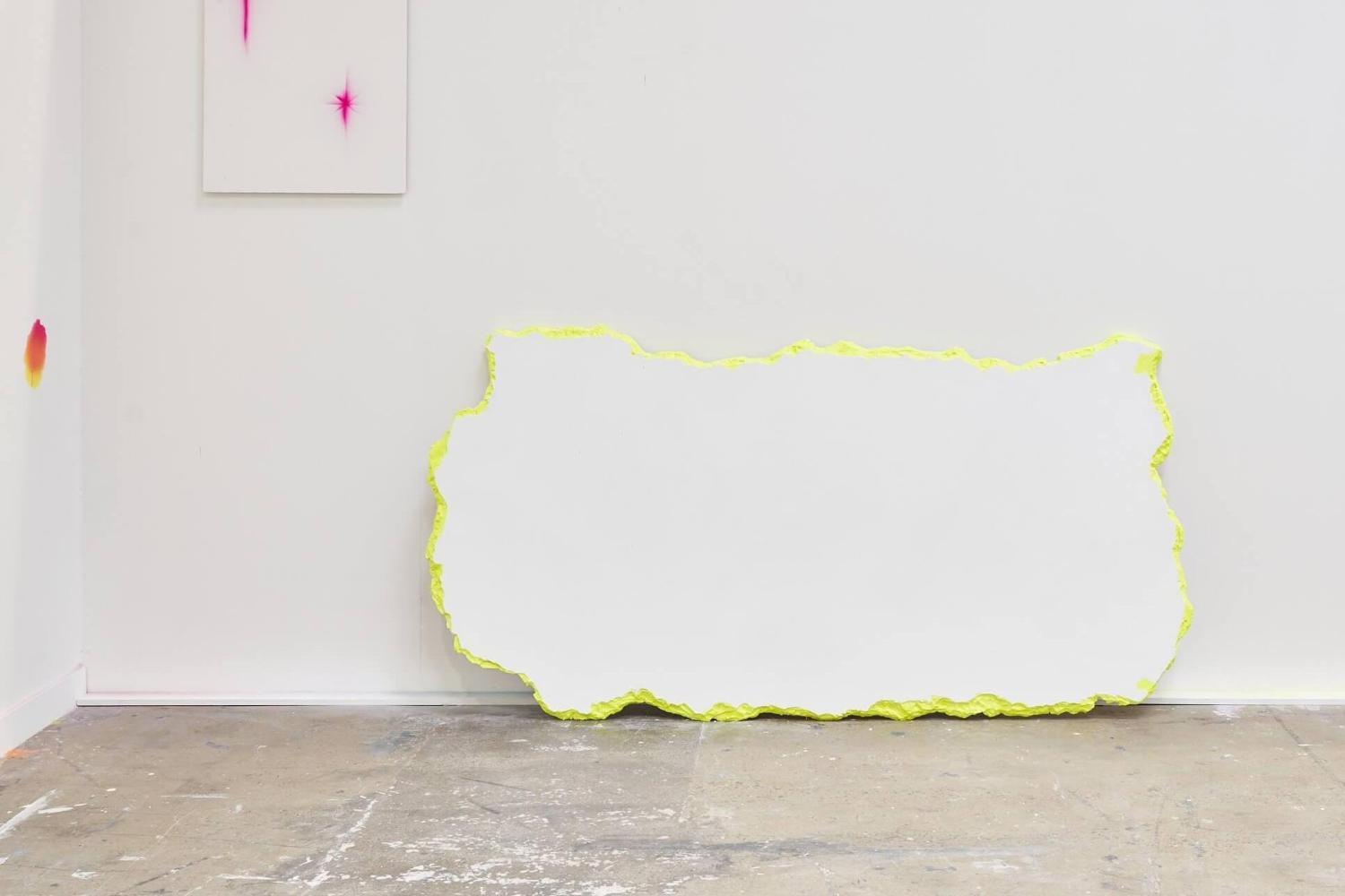 A student's exhibition at Locksbrook, with stark white walls and brightly coloured paint splotches