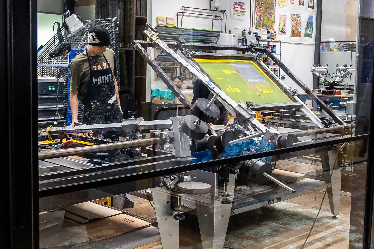 A student uses screen printing equipment at Locksbrook campus