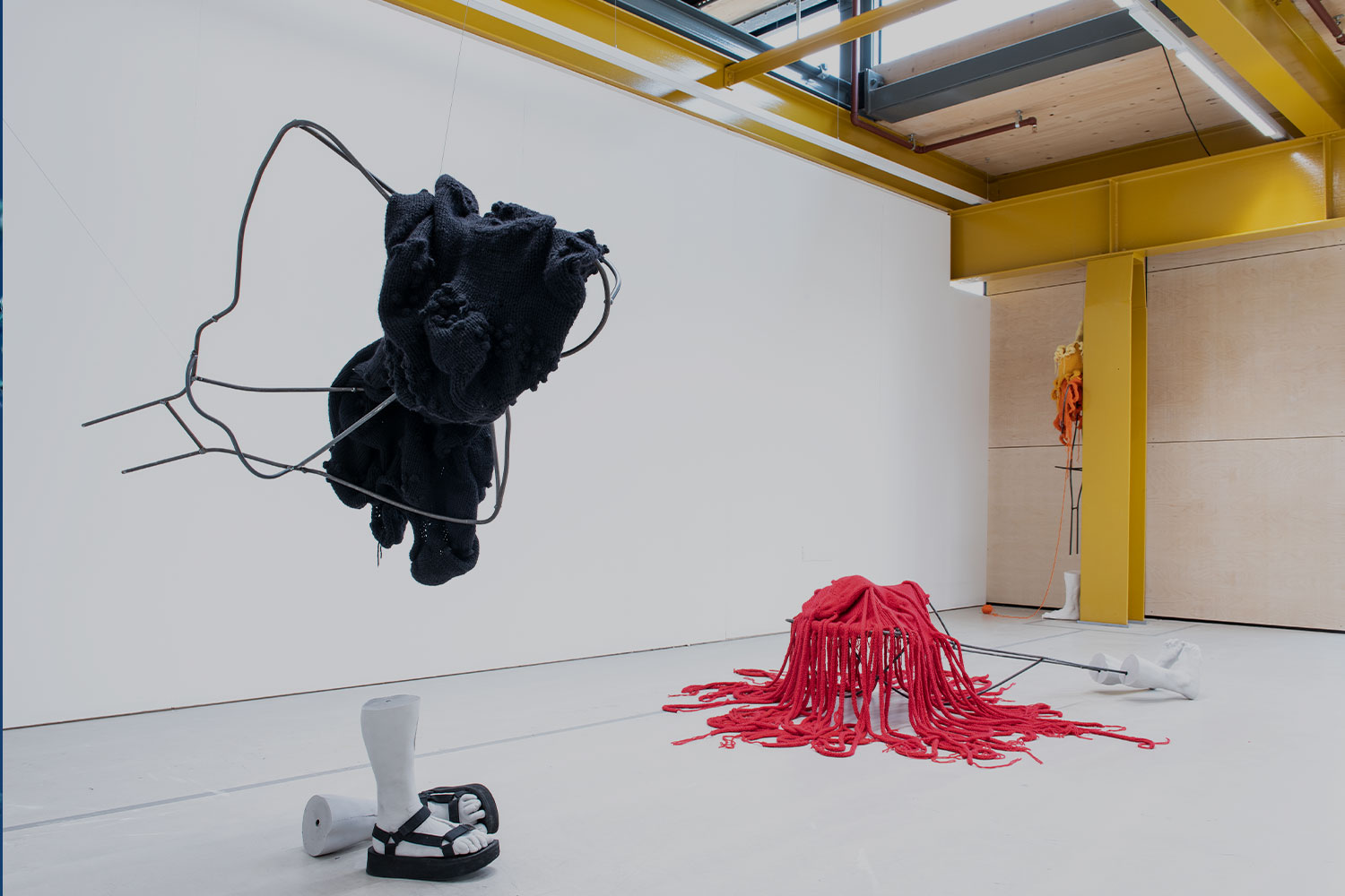 An art installation featuring mannequin parts in a white room