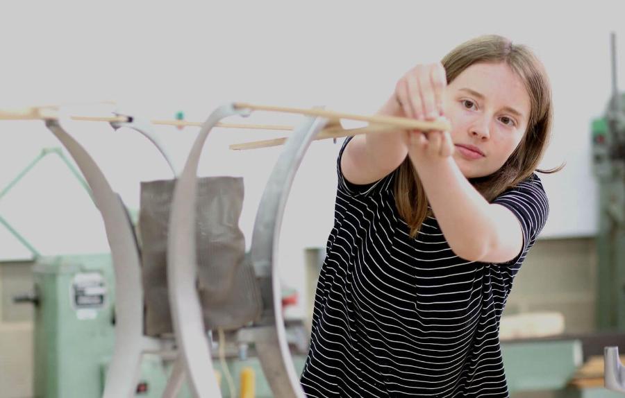 Student assembling a piece of furniture re-imagined from an old office chair