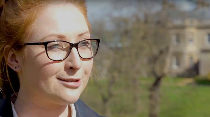 Student talking with Newton Park campus in the background