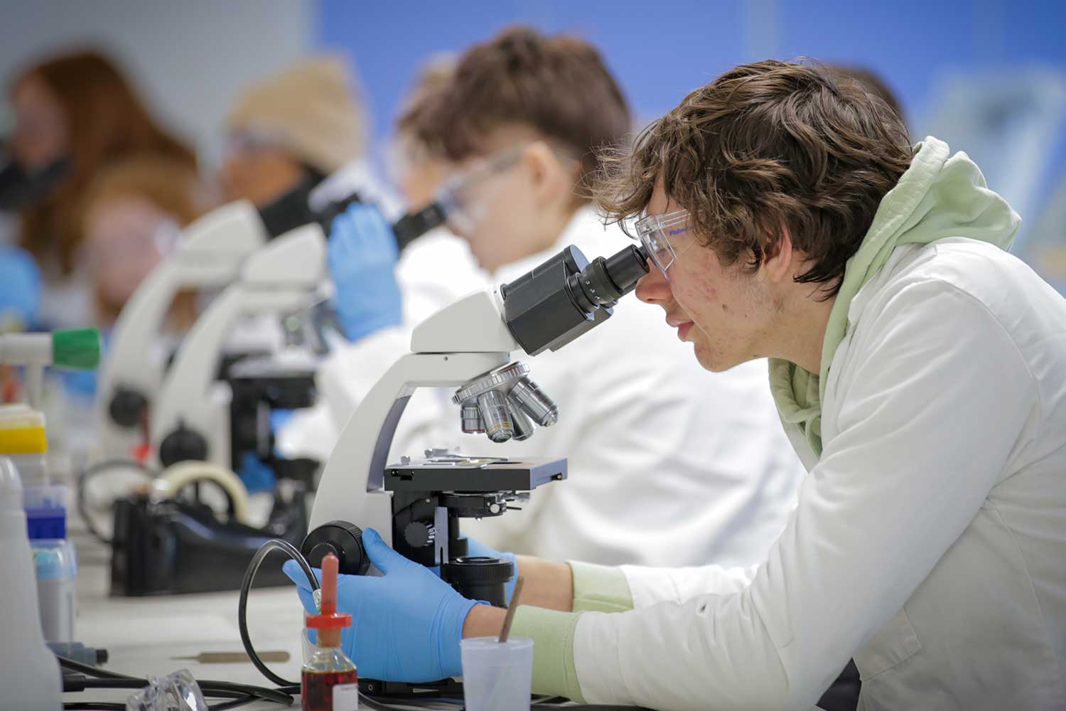 Science students use microscopes