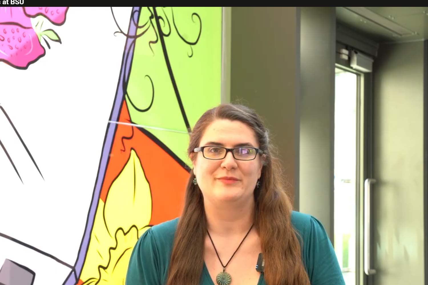 Woman with long hair and glasses in Commons building